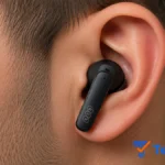 Fone Bluetooth QCY T13 preto no ouvido em foto macro lateral, evidenciando design ergonômico, tamanho compacto, conforto, ajuste seguro e qualidade premium dos earbuds sem fio.
